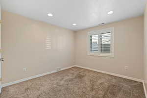 Carpeted spare room featuring recessed lighting