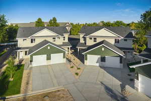 Traditional-style house featuring a residential view, stucco siding, a garage, concrete driveway, and roof with shingles