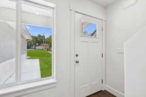 Entryway with dark wood finished floors and baseboards