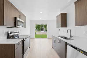Kitchen with stainless steel appliances, light stone countertops, modern cabinets, light wood finished floors, and recessed lighting