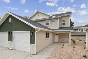 Traditional home featuring stucco siding, stone siding, and roof with shingles