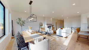 Dining area featuring light wood finished floors, recessed lighting, a chandelier, and a fireplace