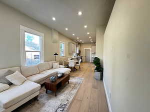 Living area featuring recessed lighting, light wood finished floors, and a textured ceiling