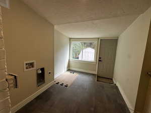 Laundry area featuring a textured ceiling, dark wood-type flooring, hookup for a washing machine, and hookup for an electric dryer