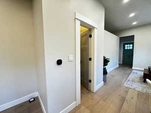 Hall with light wood-type flooring and recessed lighting