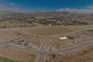 Aerial view of property and surrounding area featuring a mountain backdrop and rural landscape
