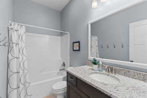 Full bath with shower / tub combo with curtain and vanity