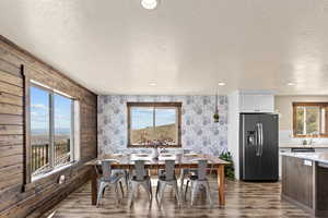 Dining area featuring a textured ceiling, dark wood finished floors, recessed lighting, and wallpapered walls
