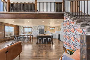Living room featuring dark wood-type flooring, wallpapered walls, and recessed lighting