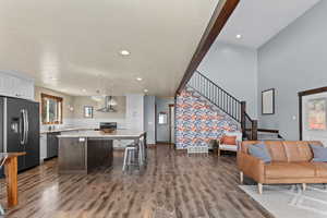 Living area with stairs, dark wood-style flooring, recessed lighting, and a textured ceiling