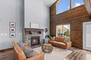 Living area featuring a towering ceiling, wood finished floors, and a fireplace