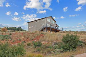 Back of property featuring stairway and a wooden deck