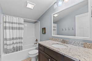 Bathroom with shower / bathtub combination with curtain, vanity, and a textured ceiling