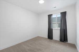Unfurnished room featuring light colored carpet and baseboards