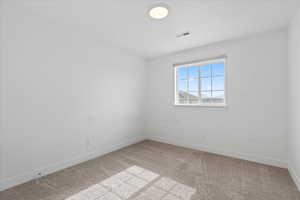 Empty room with light carpet and baseboards