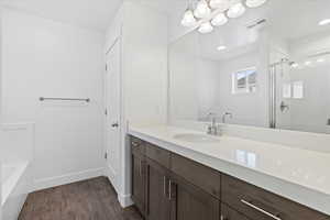Full bath with vanity, dark wood-style floors, a shower stall, and a garden tub