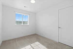 Unfurnished room featuring light colored carpet and baseboards