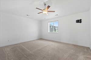 Spare room featuring light carpet and a ceiling fan