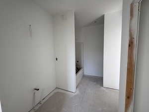 Full bathroom with unfinished concrete floors and  shower combination