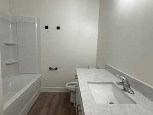 Full bathroom featuring vanity and dark wood finished floors