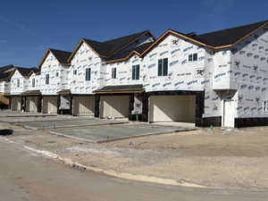 Property under construction with a residential view and a garage