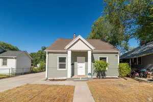 Bungalow-style home featuring roof with shingles, covered porch, board and batten siding, and a chimney