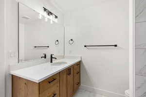 Bathroom featuring vanity and light marble finish floors