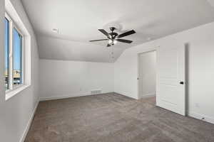 Bonus room with light carpet, vaulted ceiling, and a ceiling fan