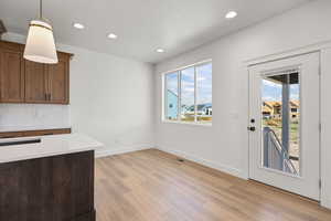 Unfurnished dining area with recessed lighting, light wood finished floors, and a residential view