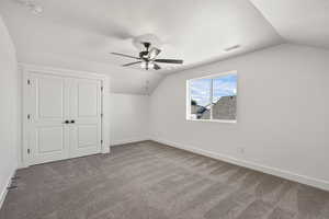 Bonus room with vaulted ceiling, carpet, a textured ceiling, and ceiling fan