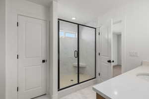 Bathroom with a stall shower, vanity, light marble finish floors, and recessed lighting