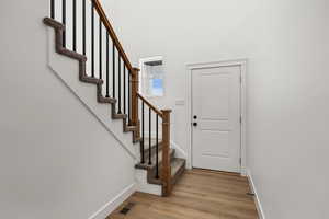 Foyer featuring light wood finished floors and stairs