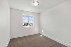 Unfurnished room featuring carpet and baseboards