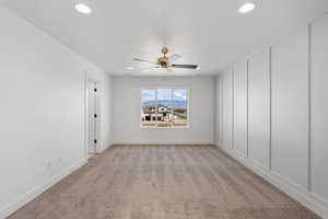 Empty room featuring light carpet, ceiling fan, and recessed lighting