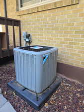 Exterior view of a cooling unit and brick siding