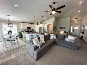 Living room featuring light wood-style floors, recessed lighting, ceiling fan, arched walkways, and a textured ceiling