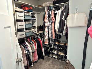 Walk in closet with dark carpet