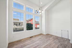 Unfurnished dining area featuring a chandelier, light wood finished floors, and recessed lighting