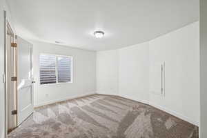 Carpeted spare room with baseboards