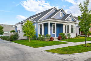 View of front of house with covered porch and roof with shingles