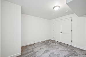 Bonus room with light carpet and baseboards