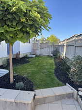 Fenced backyard featuring a gate and a patio