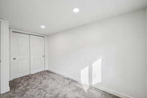 Unfurnished bedroom featuring carpet flooring, a closet, and recessed lighting