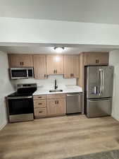 Kitchen featuring appliances with stainless steel finishes, light wood finished floors, and light brown cabinets