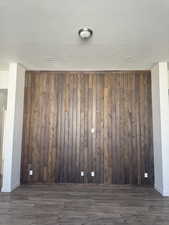 Empty room featuring dark wood finished floors and wooden walls