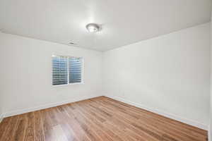 Spare room featuring light wood-style floors and baseboards