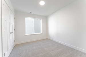 Unfurnished bedroom with light colored carpet and a closet