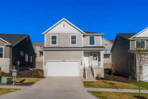 View of front facade with driveway, an attached garage, and a porch