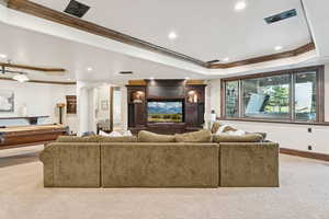 Carpeted cinema room featuring a raised ceiling, crown molding, billiards, arched walkways, and recessed lighting