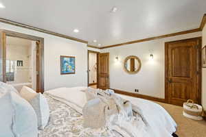 Carpeted bedroom with crown molding, connected bathroom, and recessed lighting